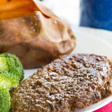 Pan seared cube steak on a plate with side dishes.