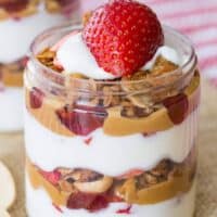 A parfait with layers of yogurt, peanut butter, jelly, and granola.