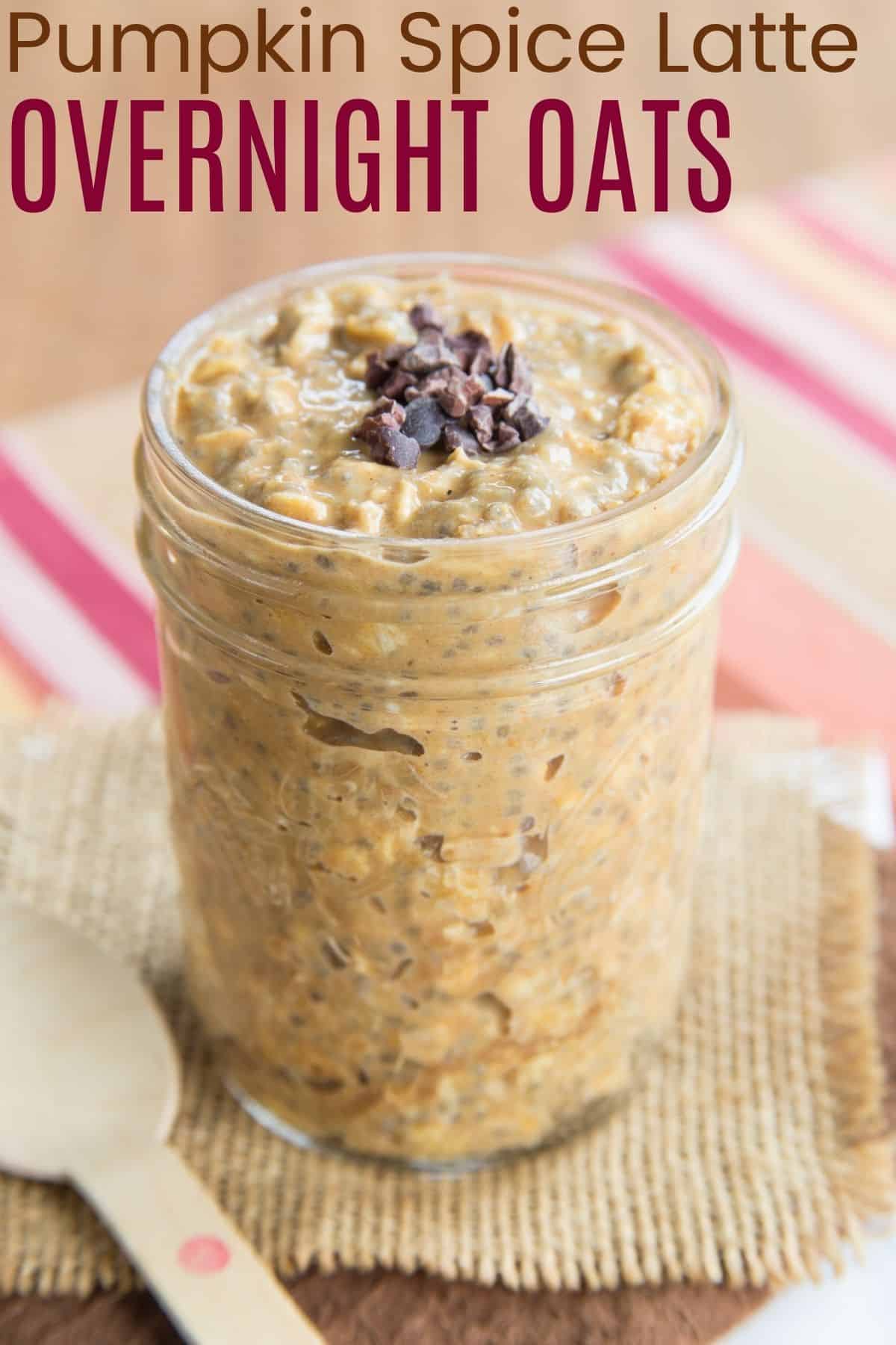 A mason jar filled with pumpkin overnight oatmeal next to a spoon