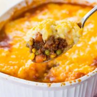 a spoonful of shepherds pie held up over a casserole dish