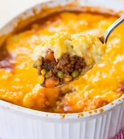 a spoonful of shepherds pie held up over a casserole dish