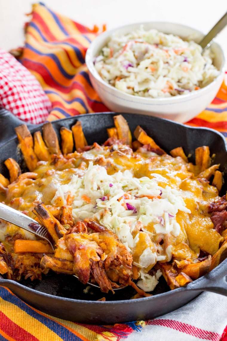 Taking a scoop of BBQ Pulled Pork Loaded Sweet Potato Fries