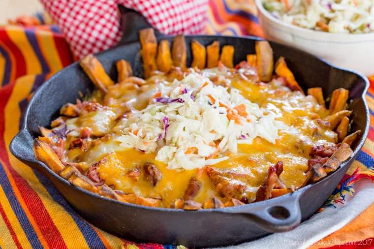 BBQ Fries topped with pulled pork and coleslaw in a cast iron skillet