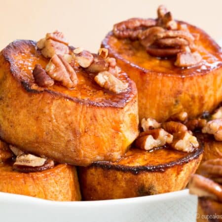 Golden brown pumpkin pie spice melting sweet potatoes served with maple-glazed pecans in a serving dish