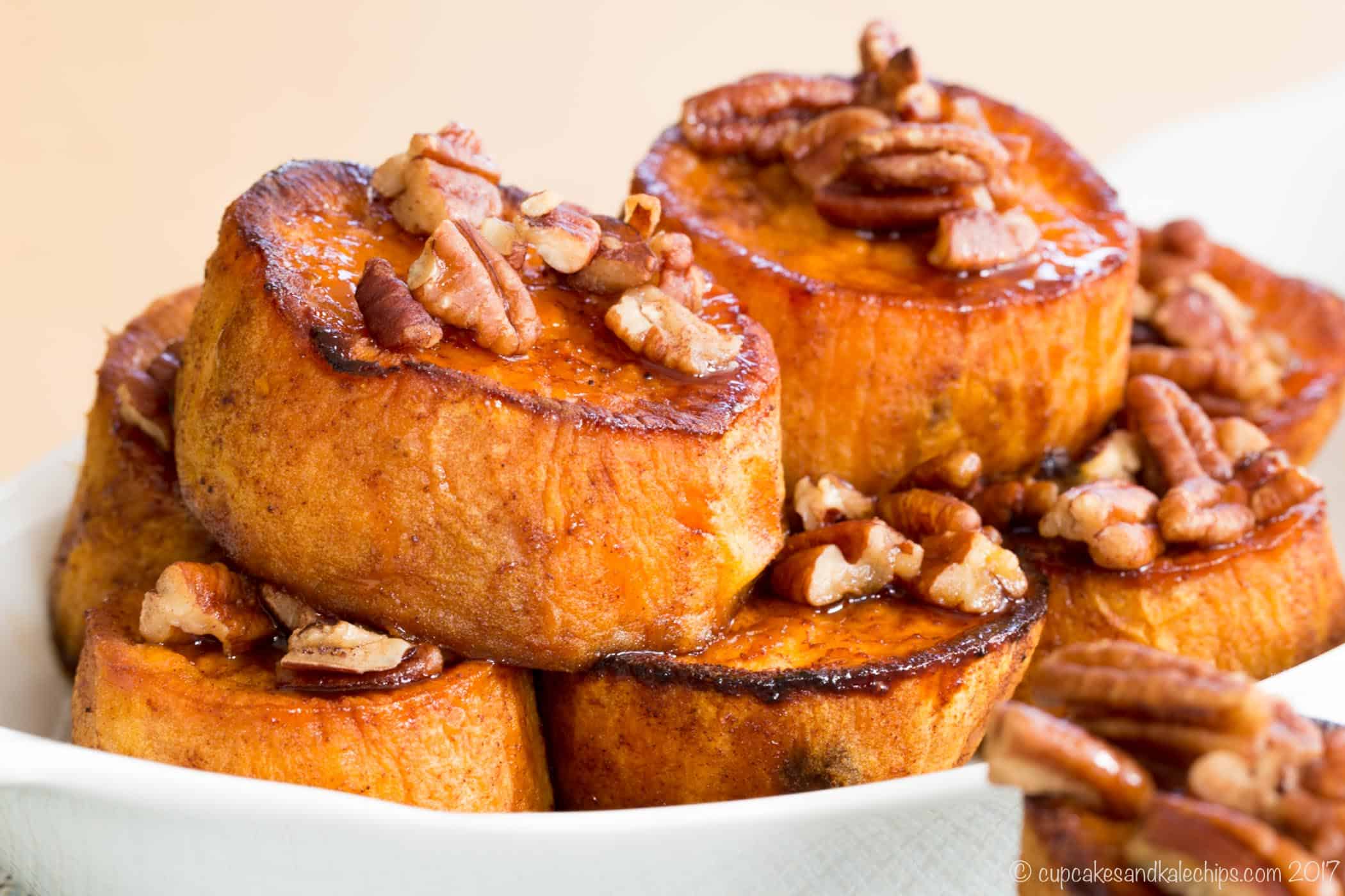 Golden brown pumpkin pie spice melting sweet potatoes served with maple-glazed pecans in a serving dish
