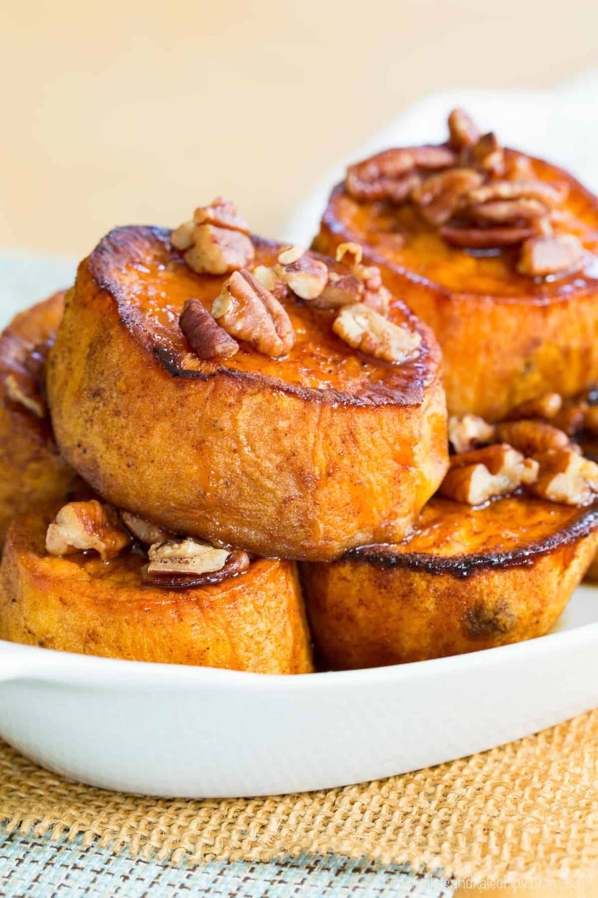 A stack of pumpkin pie spice melting sweet potatoes with maple glazed pecans in a serving dish