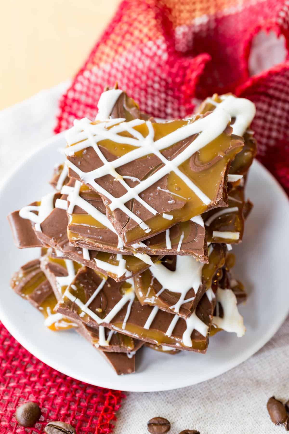 Looking down at the caramel and white chocolate swirls on top of pieces of espresso chocolate bark on a plate.