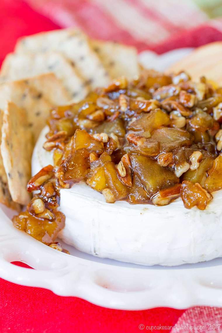 Caramelized Apple Pecan Baked Brie is served surrounded by crackers