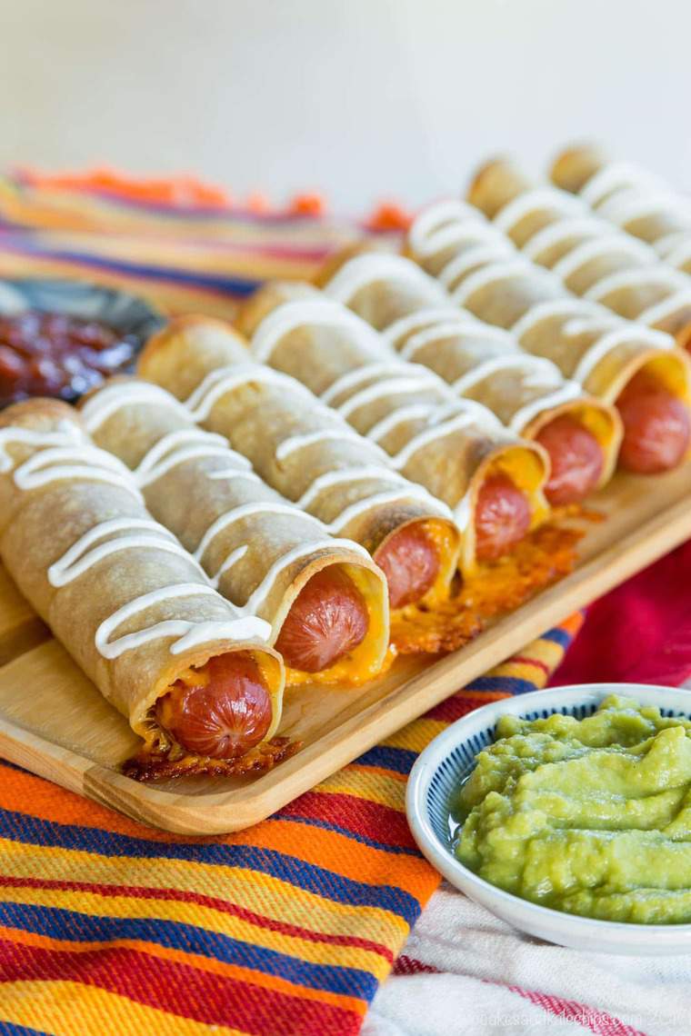 Mexican Hot Dogs Baked Taquitos on a wooden serving plate