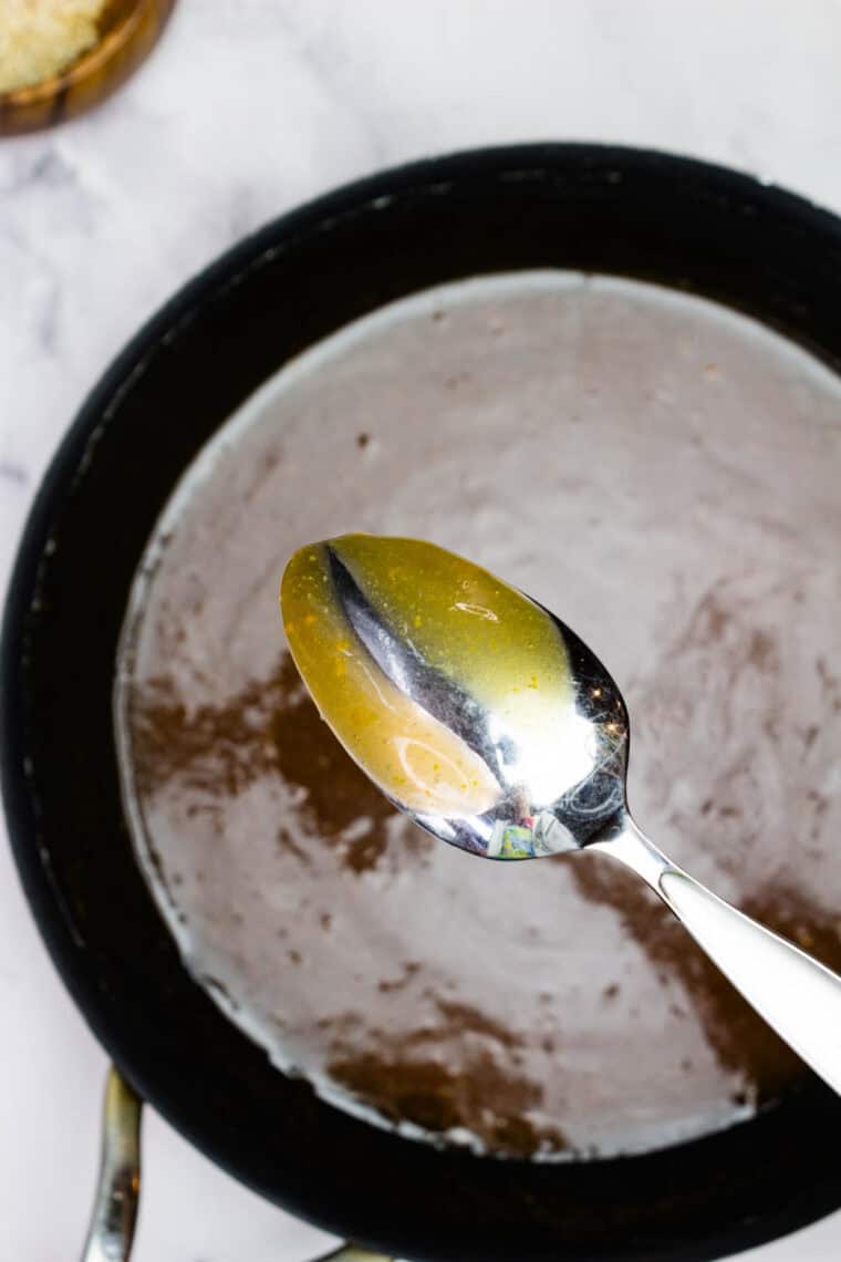 A spoon in orange sauce