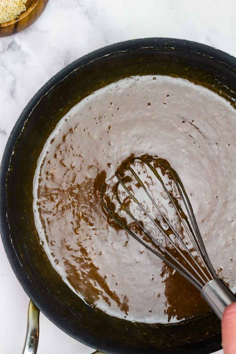 Whisking orange sauce in a pan