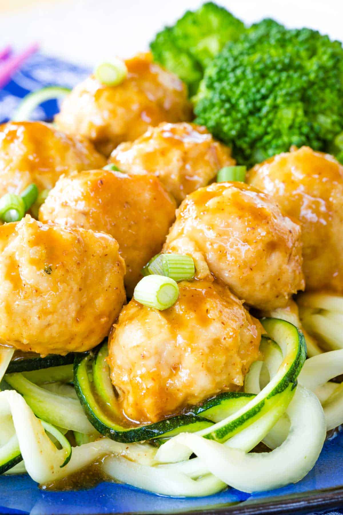 General Tso's Chicken Meatballs served over zoodles, brown rice, and steamed broccoli.