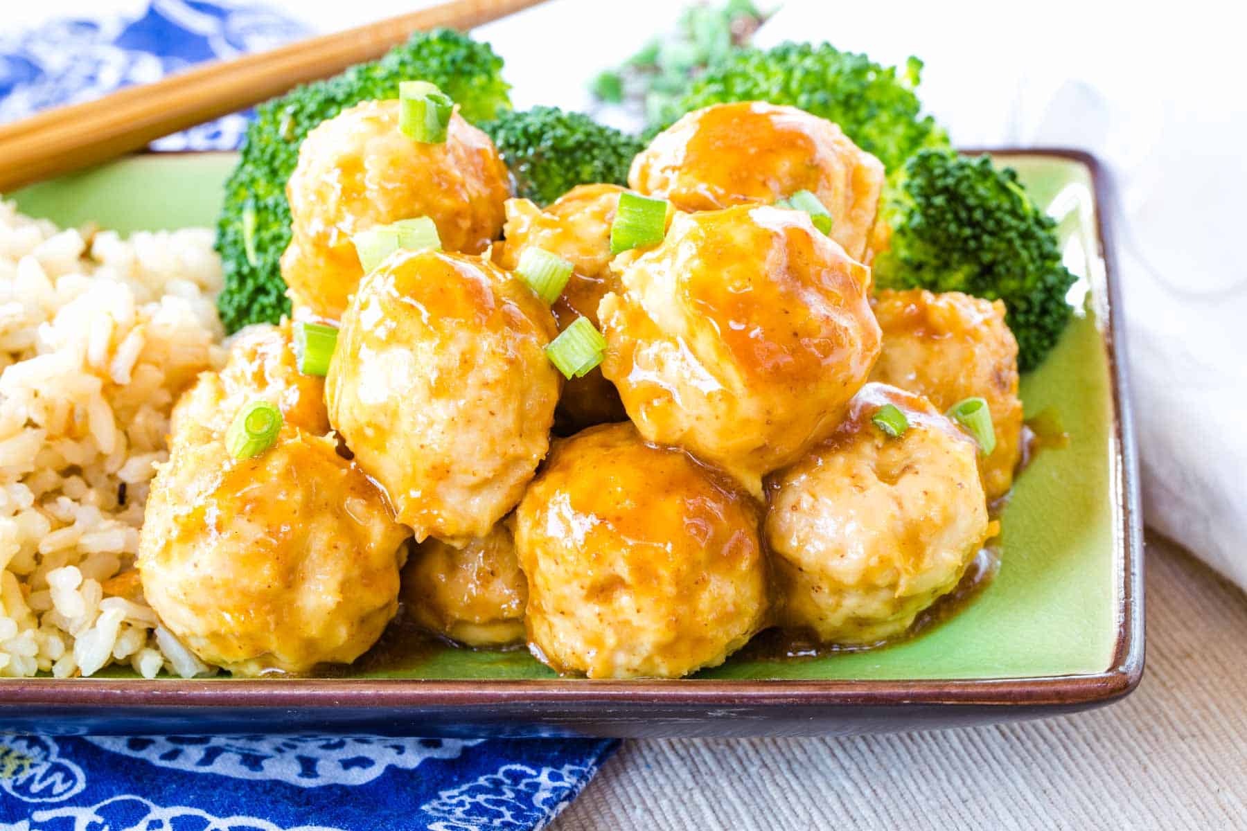 General Tso's Chicken Meatballs served over zoodles, brown rice, and steamed broccoli.