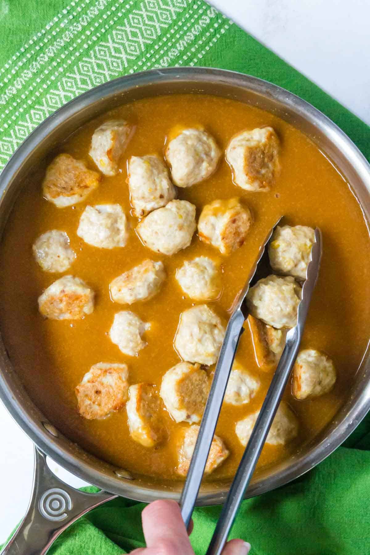 Baked chicken meatballs are added into the pot with the prepared General Tso's sauce.