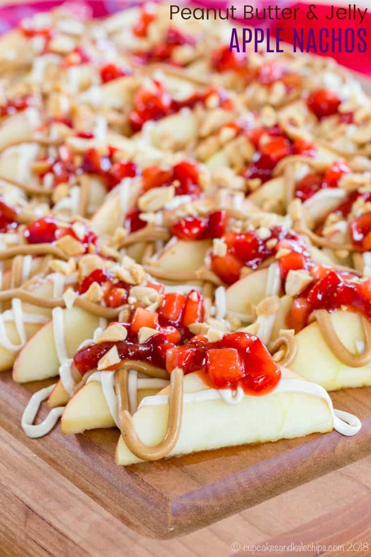 Peanut Butter and Jelly Apple Nachos - sliced apples topped with peanut butter, strawberry salsa, and a Greek yogurt cheesecake drizzle make a healthy snack recipe kids and adults will love. It's quick and easy to make with the favorite PB&J sandwich combination from sponsors Smucker's and Jif! #cupcakesandkalechips #applenachos #snackrecipe #glutenfree #snack #peanutbutterandjelly #pbandj