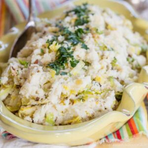 Cauliflower colcannon in a serving bowl garnished with chives.