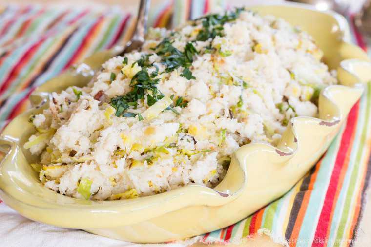 Cauliflower colcannon in a serving bowl garnished with chives.