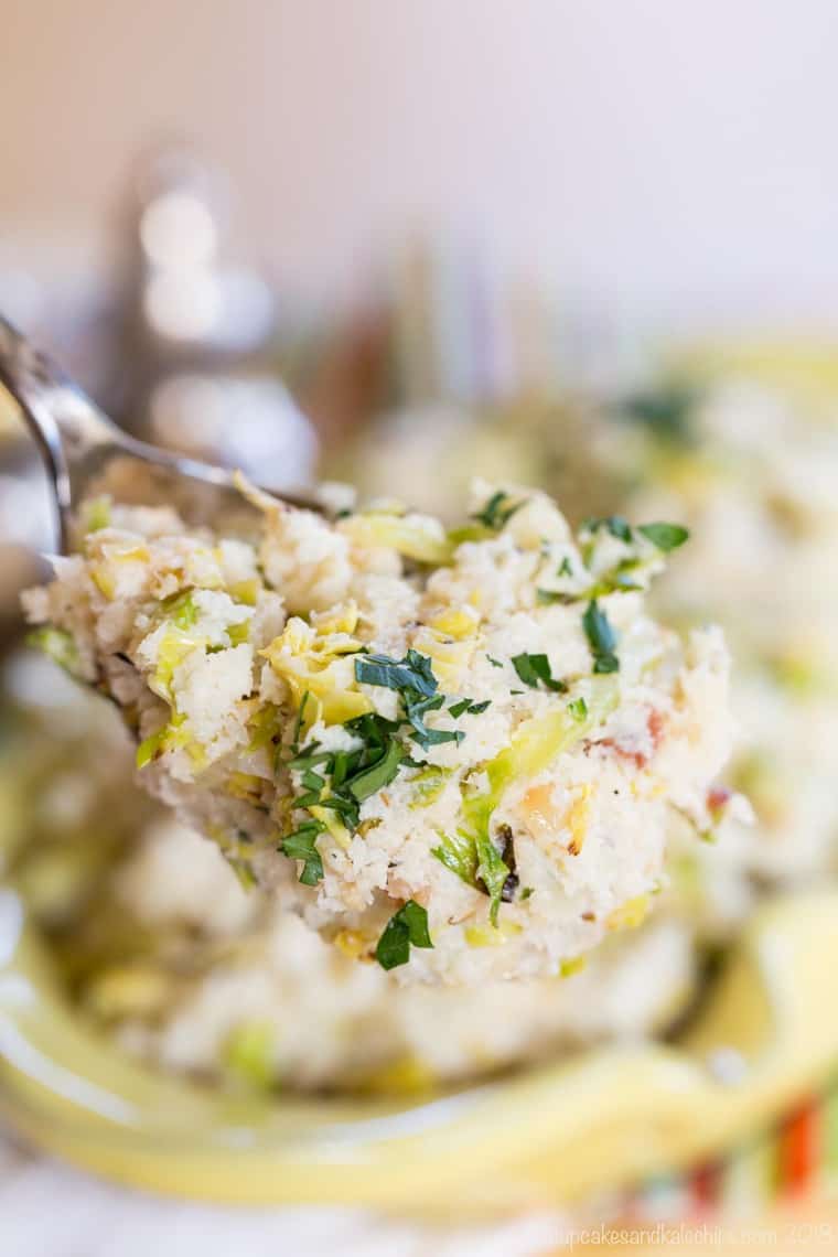 Cauliflower colcannon in a serving bowl garnished with chives.