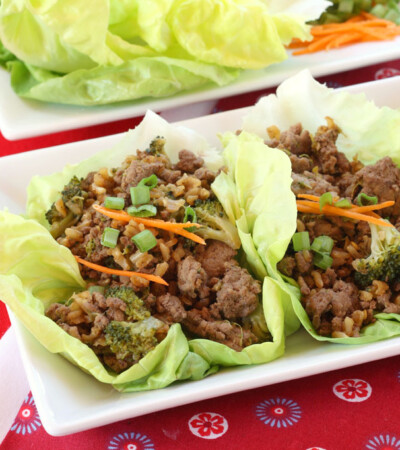 Two beef and broccoli lettuce wraps on a rectangular plate.