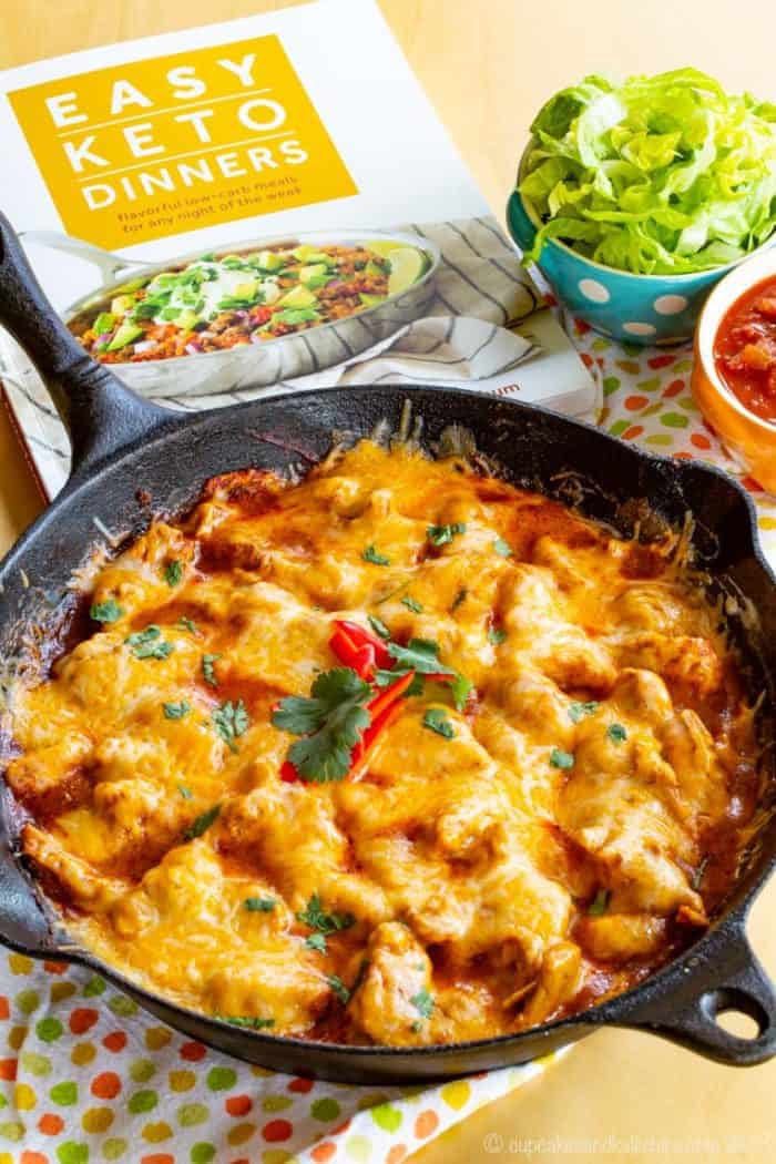 Low Carb Chicken Enchilada Skillet next to the cookbook where the recipe is from, Easy Keto Dinners by Carolyn Ketchum