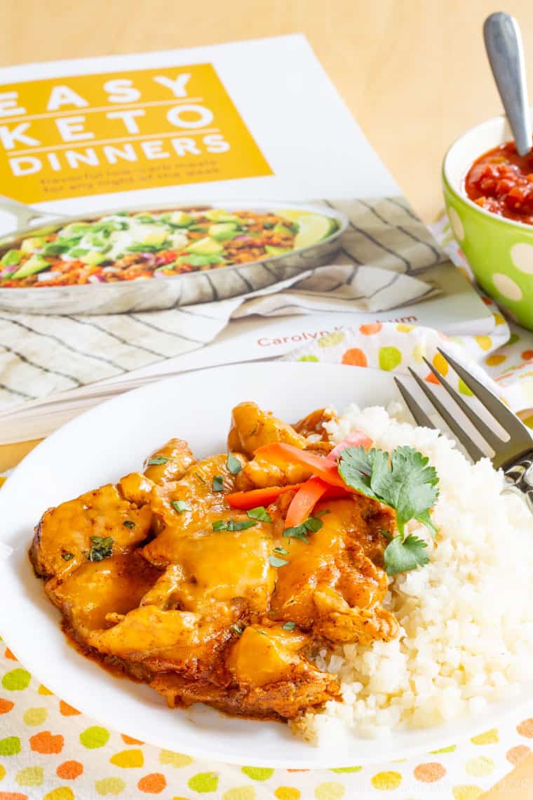 Chicken Enchilada Skillet served on a place with cauliflower rice next to the cookbook Easy Keto Dinners