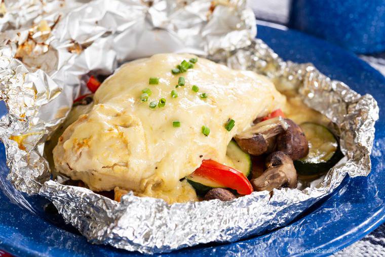 Cheesy Maple Dijon Chicken Foil Packets served in aluminum foil on a blue plate