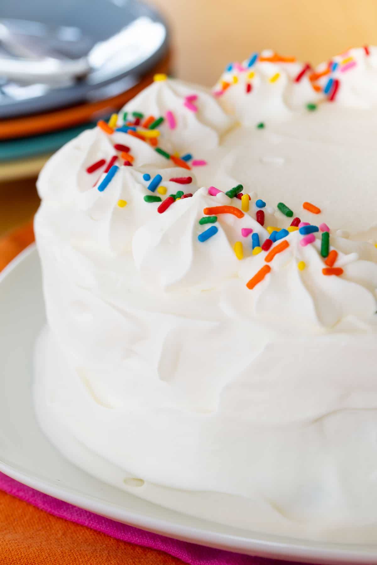 Sprinkles and whipped cream on the outside of an ice cream cake