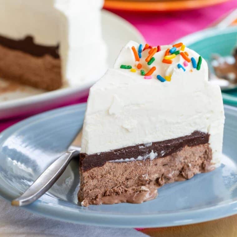 A slice of vanilla and chocolate Ice Cream Cake on a blue plate.