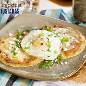 Breakfast tostadas topped with refried beans and a fried egg.