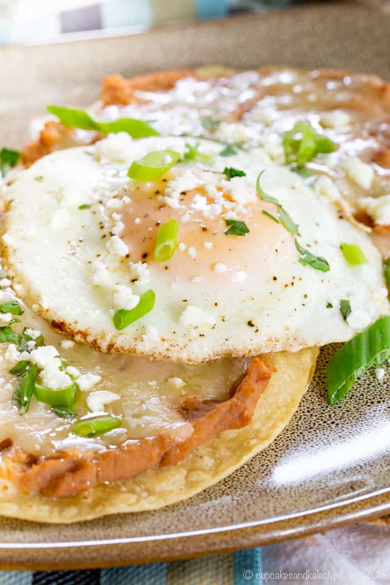 Breakfast tostadas topped with refried beans and a fried egg.