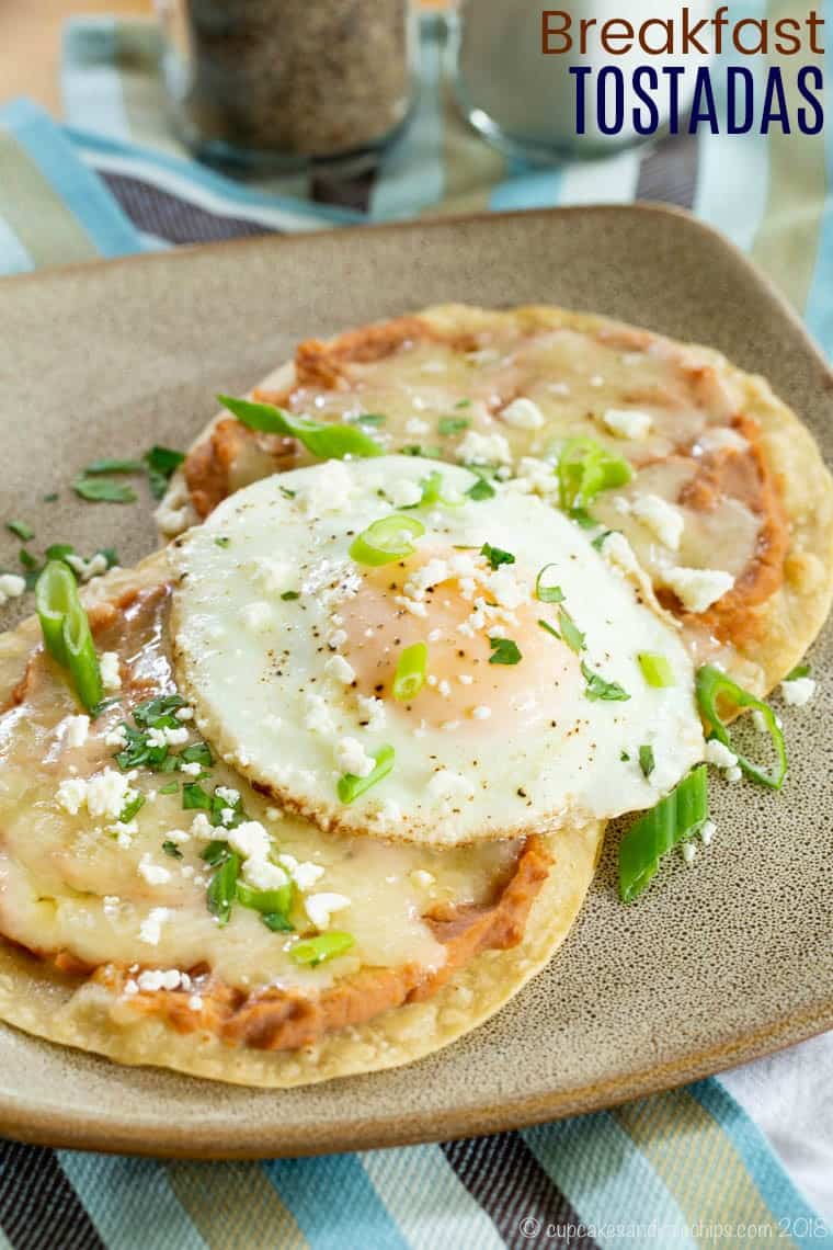 Breakfast tostadas topped with refried beans and a fried egg.