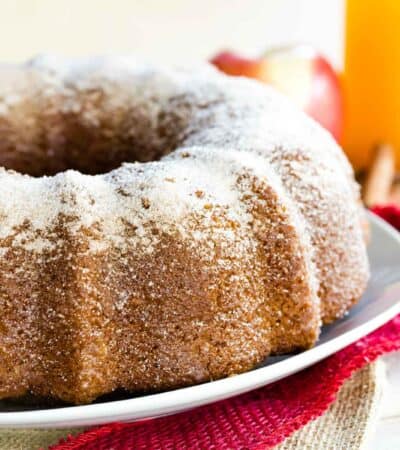 Gluten Free Apple Cider Donut Cake on a white plate with a cake server