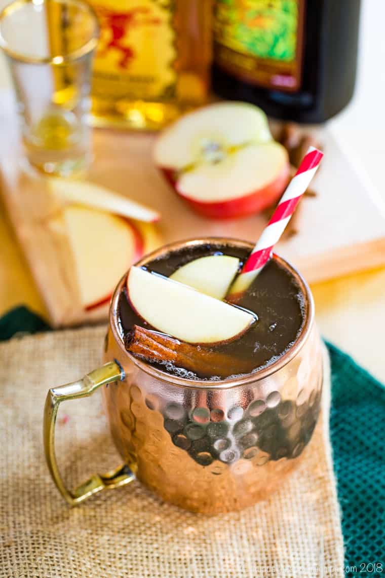 Spiced Apple Cider Moscow Mule Cocktail with apple slices and cinnamon sticks