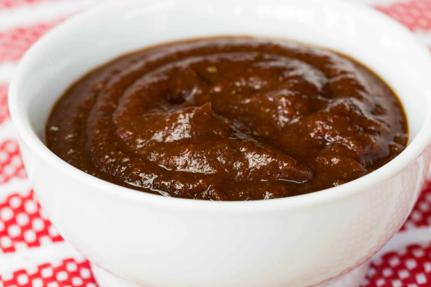 Balsamic Ketchup in a small white bowl on a red and white napkin.