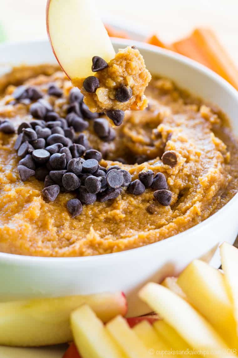 Apple slice dipped in Sweet Pumpkin Hummus with Chocolate Chips