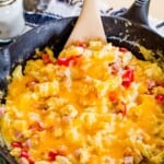 making fluffy scrambled eggs with cheese in a cast iron skillet