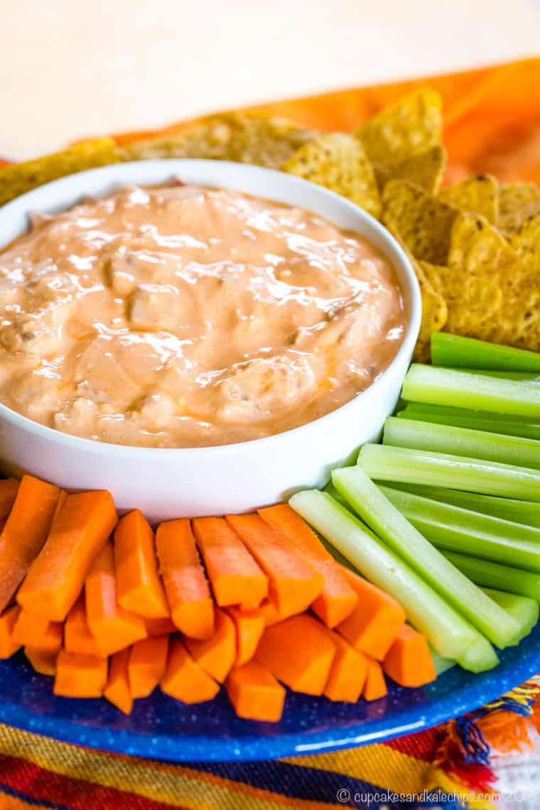 Bacon Blue Cheese Buffalo Dip on a platter with tortilla chips, carrots, and celery