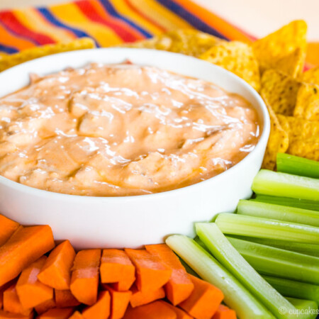 Bacon Blue Cheese Buffalo Dip on a platter with tortilla chips, carrots, and celery