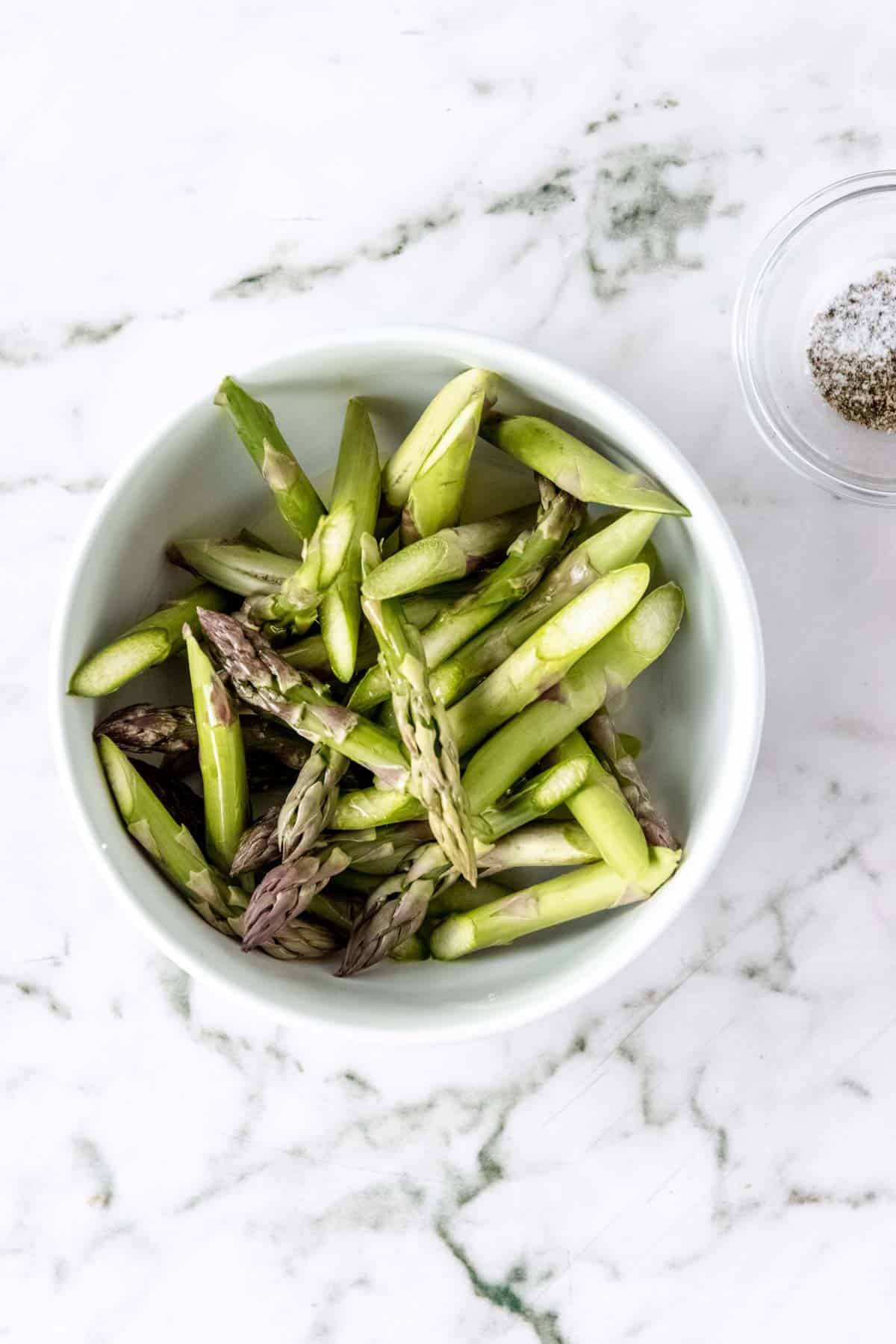 Chopped asparagus in a white bowl.