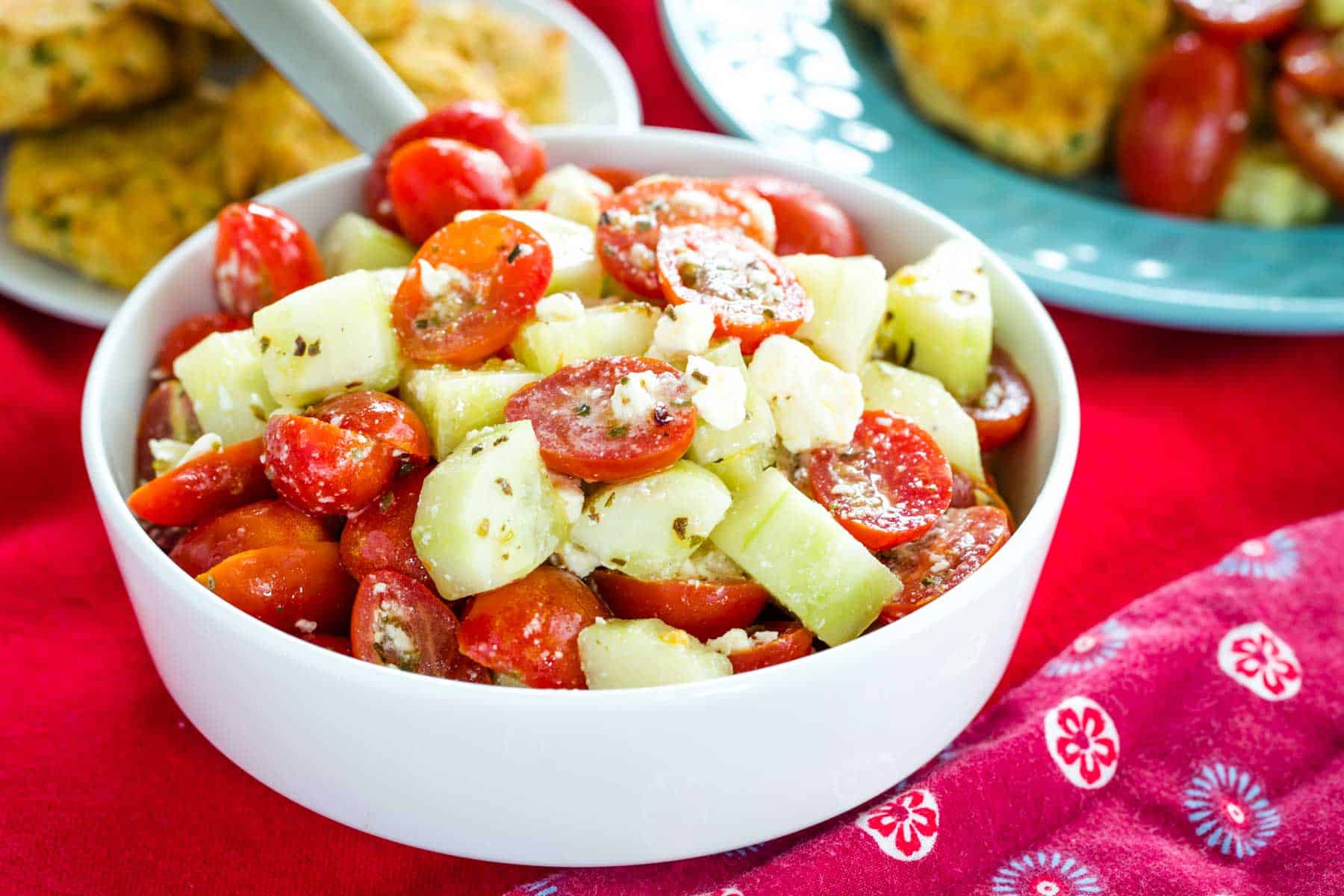 A bowl of Tomato Cucumber Salad with Feta Cheese on a red napkin