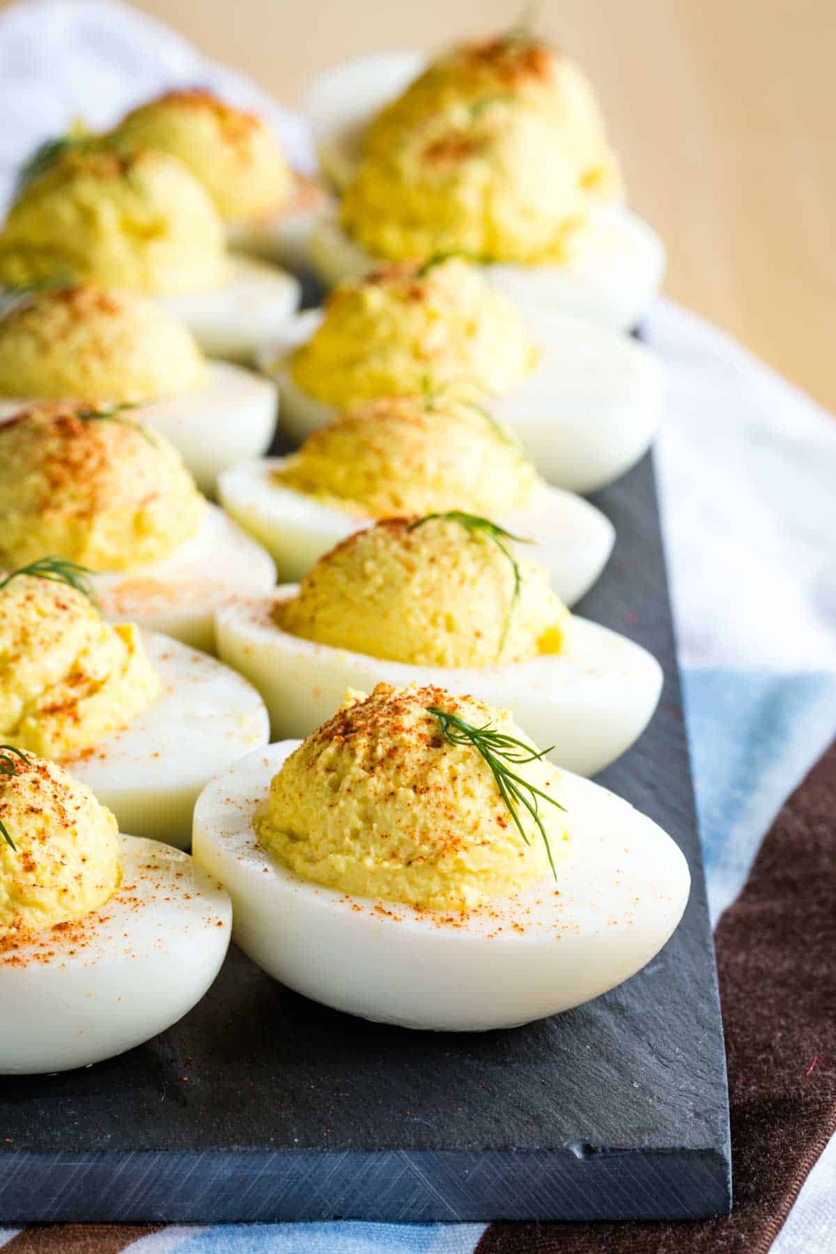 A row of Deviled Eggs on a slate serving platter.