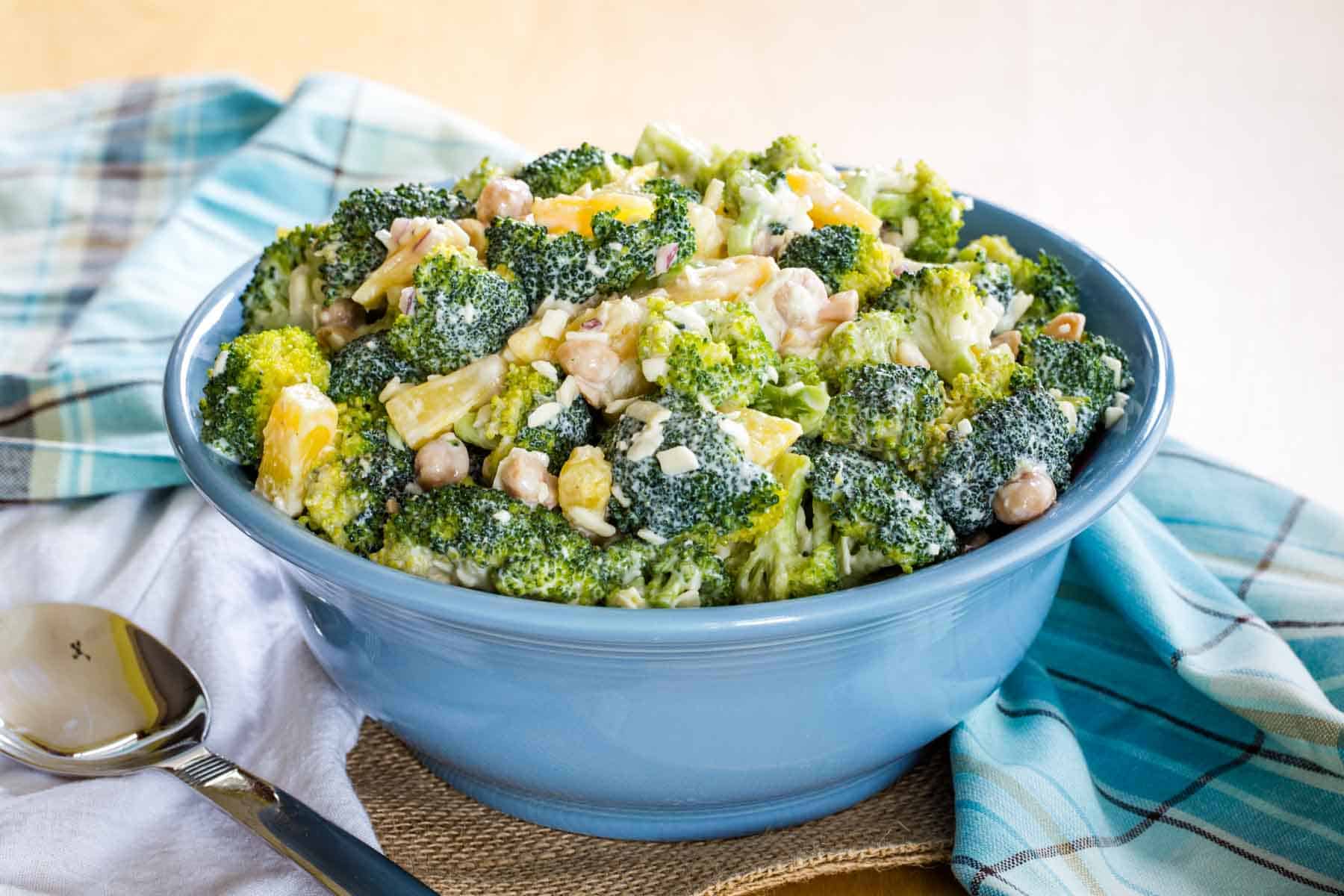 Tropical Broccoli Salad in a blue serving bowl with a spoon.