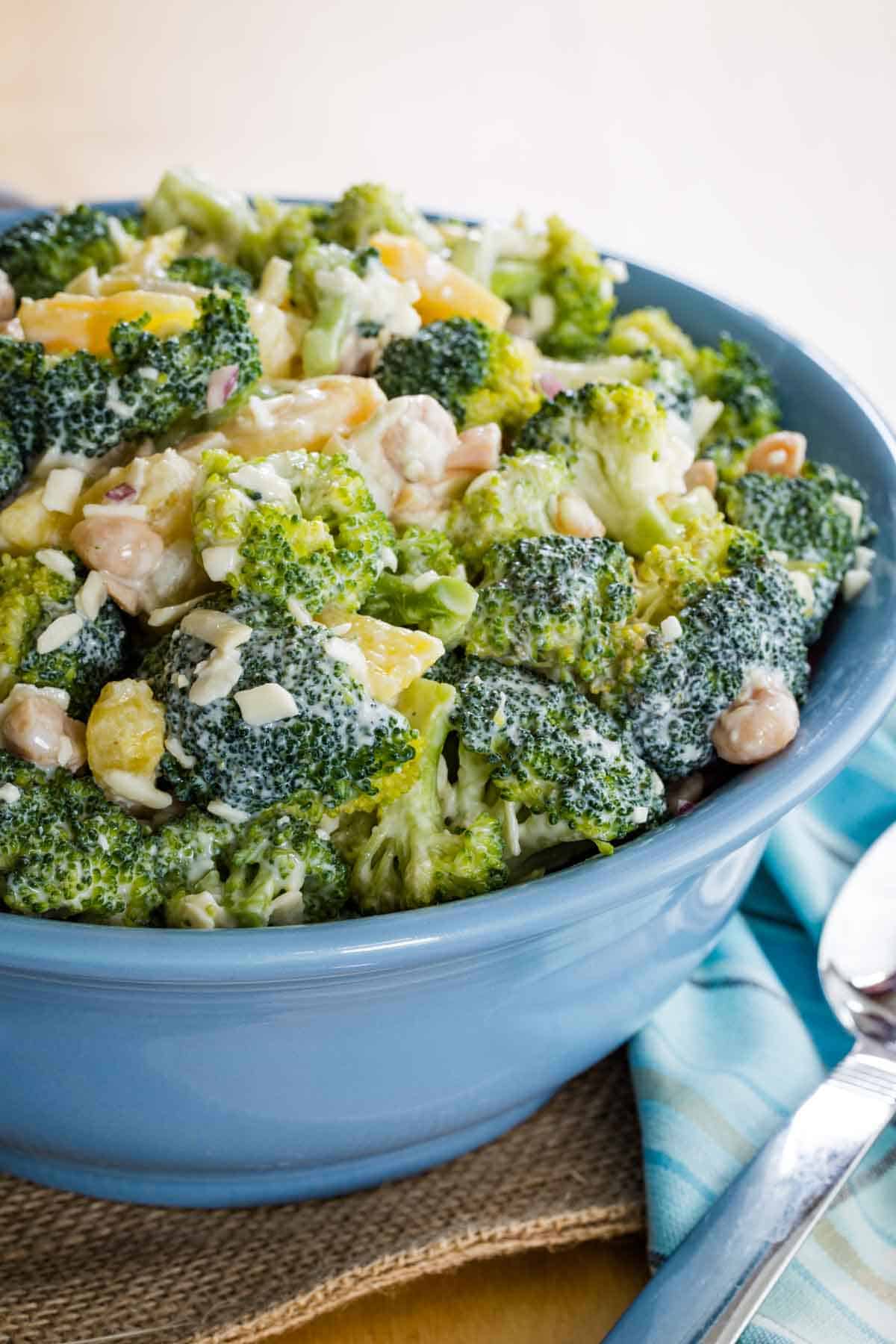 A closeup of Broccoli Pineapple Salad in a blue serving bowl.