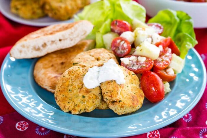 Easy gluten free falafel on a blue plate with tomato cucumber feta salad