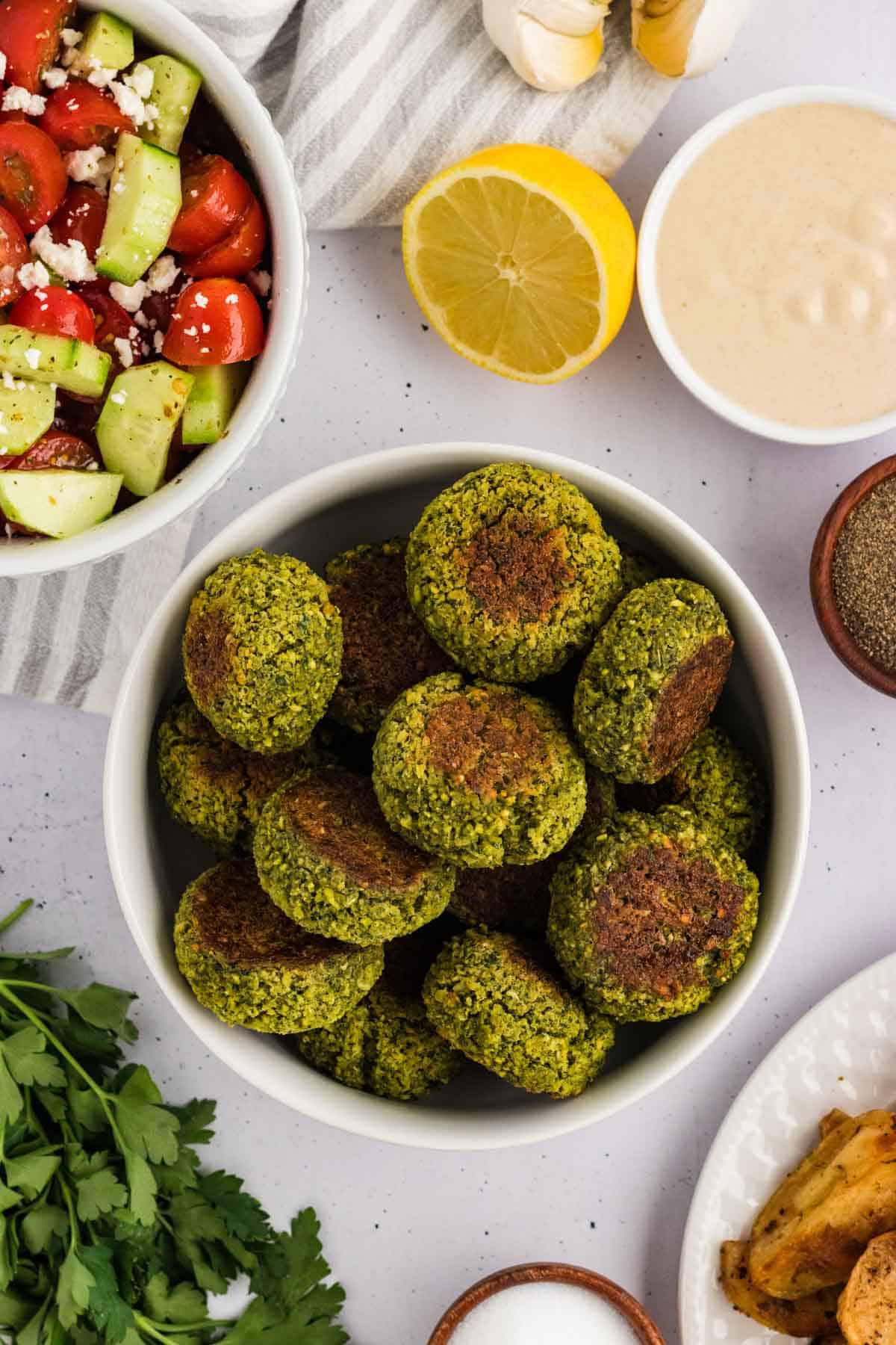 Overhead view of a white bowl of baked falafel