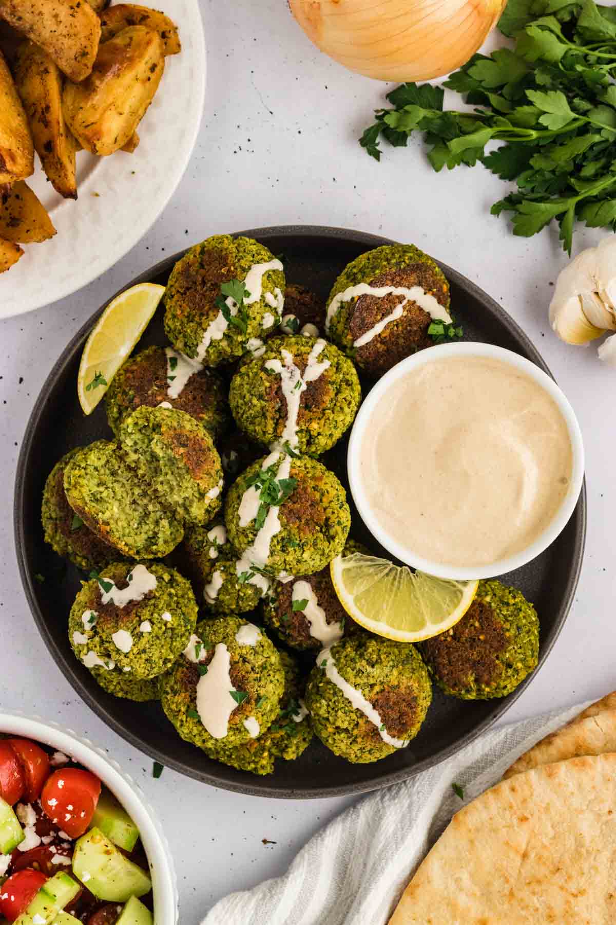 Overhead view of a bowl of baked falafel drizzled with tahini