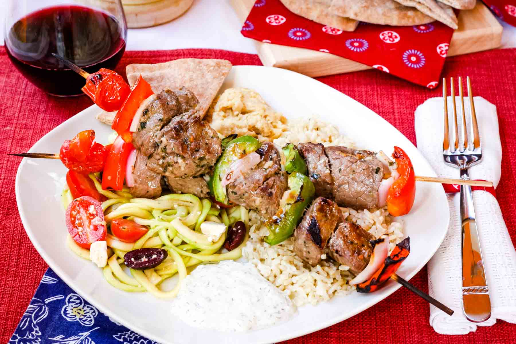 Greek Beef Kabobs with tzatziki, pita, rice, and zoodles Greek salad