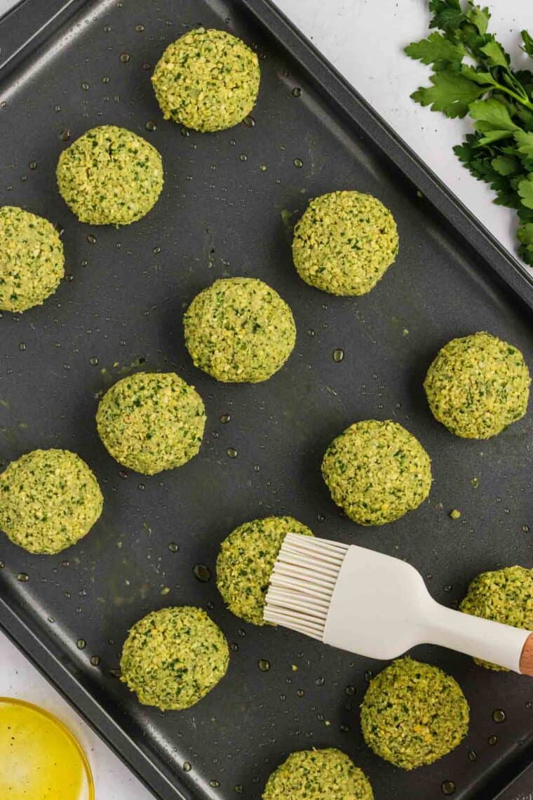 Brushing unbaked falafel with oil