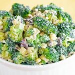 A white serving bowl of Healthy Apple Broccoli Salad with Walnuts and Cheddar