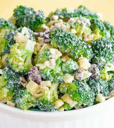 A white serving bowl of Healthy Apple Broccoli Salad with Walnuts and Cheddar